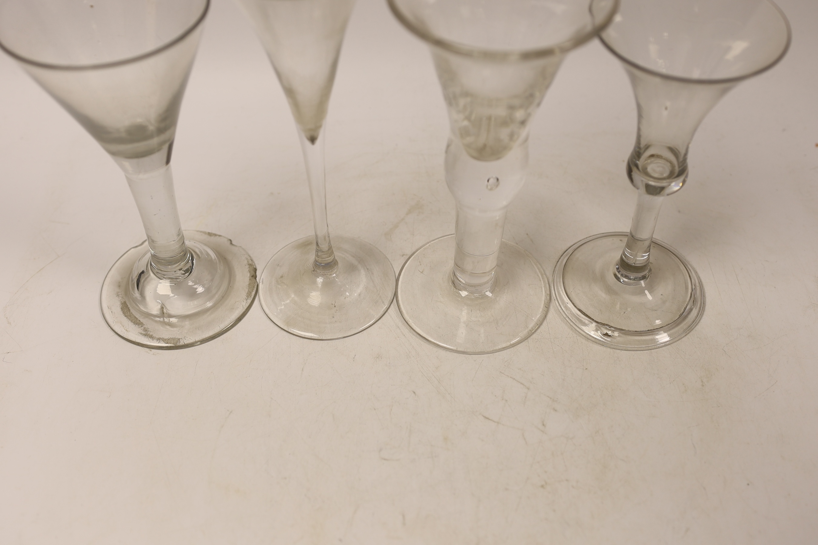 Three mid-18th century plain stem wine glasses, two with trumpet shaped bowls and a bell-shaped example with a folded foot, together with a reproduction drinking glass, tallest 20cm (4)
